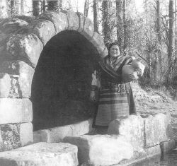 Mujer posando cuando va a buscar agua a la fuente con el cántaro